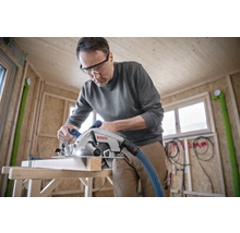 Mann schneidet Holz mit einer Bosch Handkreissäge in einem Rohbau