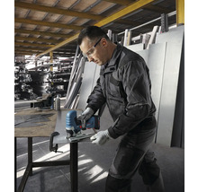 Ein Mann schneidet mit einer Akku-Stichsäge ein Metallblech