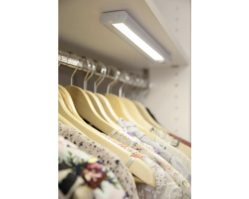 Kleiderschrank mit LED-Beleuchtung und Kleidung an Kleiderbügeln