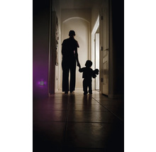 Silhouette einer Person, die mit einem Kind durch einen dunklen Flur geht