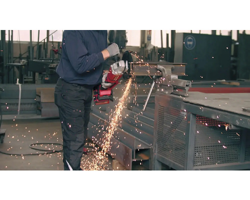 Ein Mann schneidet mit einem Winkelschleifer ein Metallstück ein.