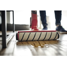 Aufsicht auf einen Waschsauger in Aktion auf einem Holzboden.