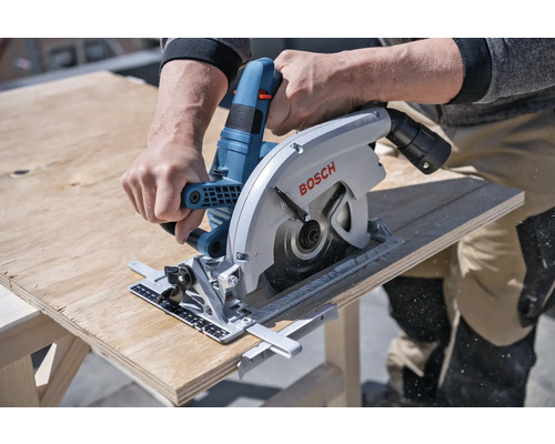 Eine Handkreissäge beim Schneiden eines Holzbretts. Bosch Logo.