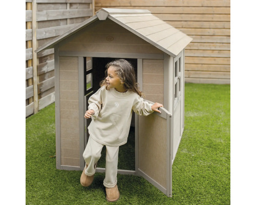 Kind verlässt ein Spielhaus aus Holz im Garten.
