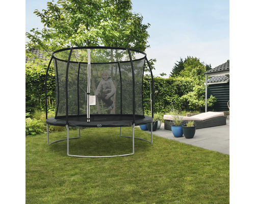 Kind springt auf einem runden Gartentrampolin mit Sicherheitsnetz.