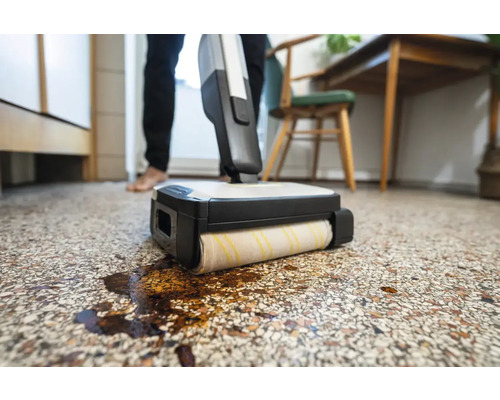 Bodenreinigungsgerät im Einsatz auf einem gemusterten Boden mit Flüssigkeit
