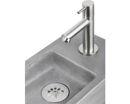 Waschbecken aus Beton mit Edelstahlarmatur und Abfluss