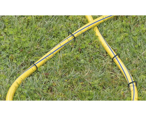 Gelber Gartenschlauch mit Schlauchhaltern im Gras