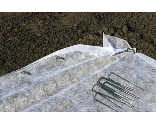 Gartenvlies mit Befestigungsnägeln auf dem Boden