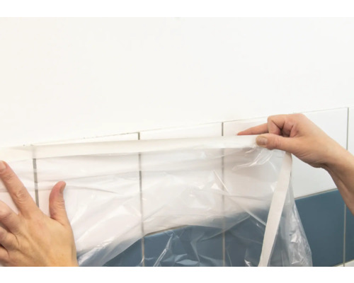 Abdeckfolie wird an Wandfliesen angebracht