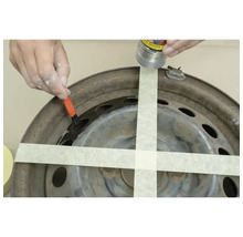 Eine Person trägt Rostschutz auf eine Autofelge auf