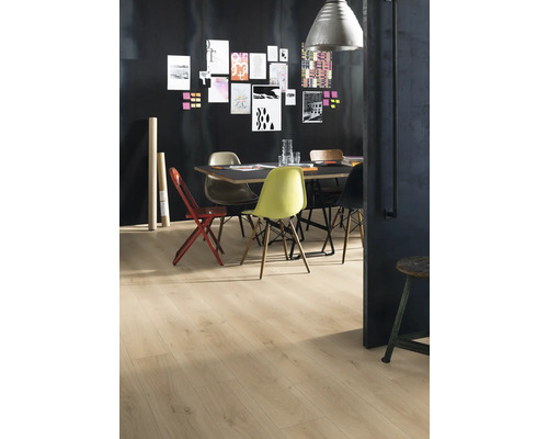 Ein Esszimmer mit Holzboden, einem Tisch und verschiedenen Stühlen vor einer dunklen Wand mit Notizen.