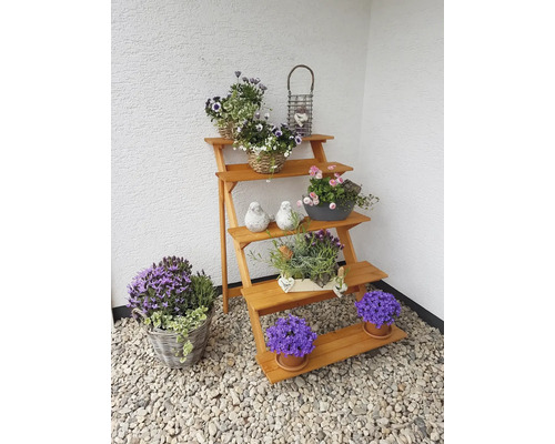 Holzpflanzentreppe mit Blumen in Töpfen und Körben als Gartendekoration.