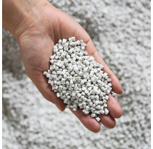 Hand hält Katzenstreu aus Mineralgranulat