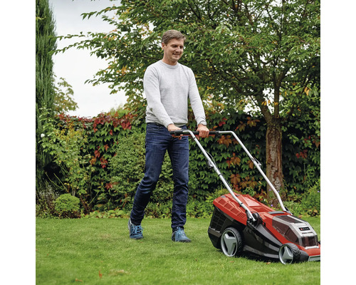 Mann bedient Rasenmäher im Garten