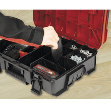 Geöffnete Werkzeugbox mit Zubehör und Hand