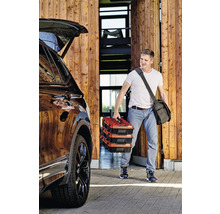 Mann trägt drei Werkzeugkoffer zum Auto