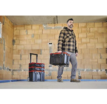 Handwerker mit Werkzeugkoffer in einem Rohbau