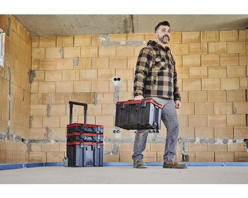 Handwerker mit Werkzeugkoffer in einem Rohbau