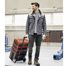 Handwerker mit Werkzeugkoffer Trolley in einer Werkstatt