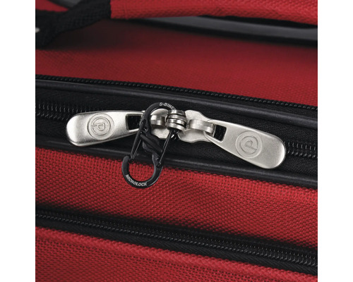 Detailansicht eines roten Koffers mit silberfarbenen Reißverschlüssen und schwarzem S-Biner