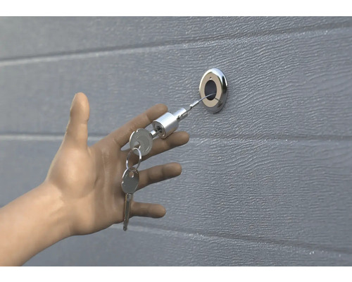 Hand öffnet Garagentor mit Schlüssel