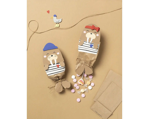 Zwei Geschenkverpackungen mit Walross-Motiv, gefüllt mit Süßigkeiten.