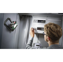 Elektriker arbeitet an Sicherungskasten mit LED-Arbeitsleuchte