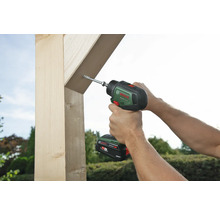 Eine Person schraubt mit einem Akkuschrauber eine Schraube in ein Holzstück.