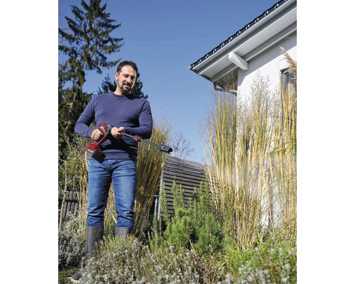 Mann verwendet Akku-Druckreiniger im Garten.