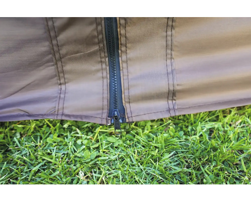 Detailansicht eines Zeltreißverschlusses mit Gras im Vordergrund.