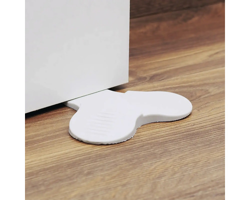 Weißer Türstopper aus Kunststoff hält eine Tür offen