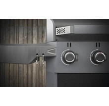 Detailansicht eines Holzkohlegrills mit Drehknöpfen und Ablagefläche