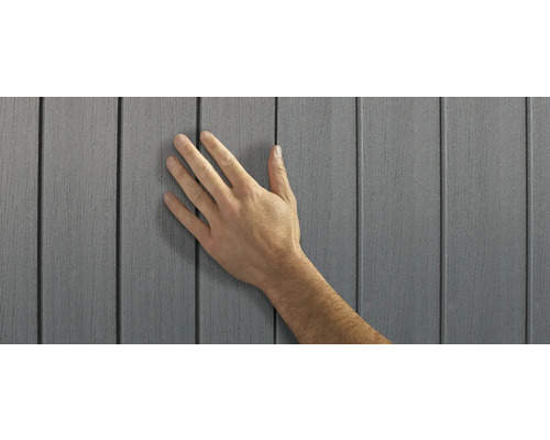 Hand berührt graue Fassadenverkleidung aus Kunststoff