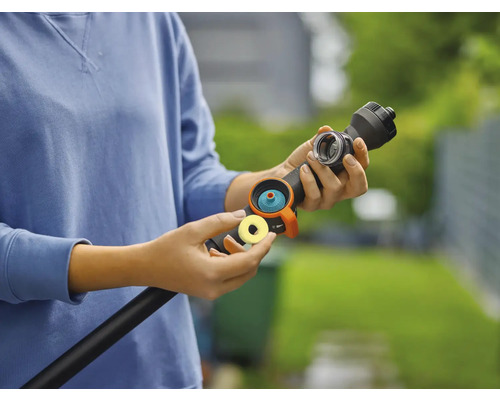 Eine Person verbindet eine Gartenschlauchkupplung mit einem Gartenschlauch