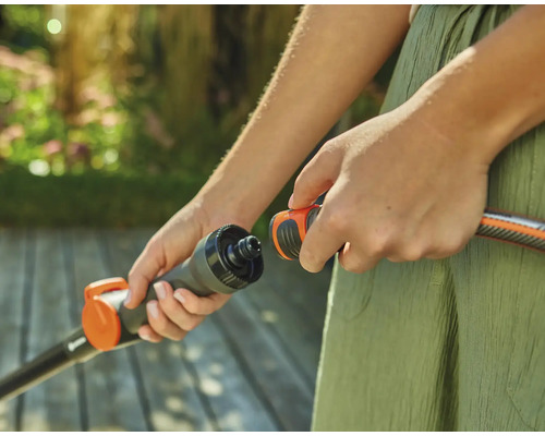 Person verbindet Gartenschlauch mit einem Anschlussstück.