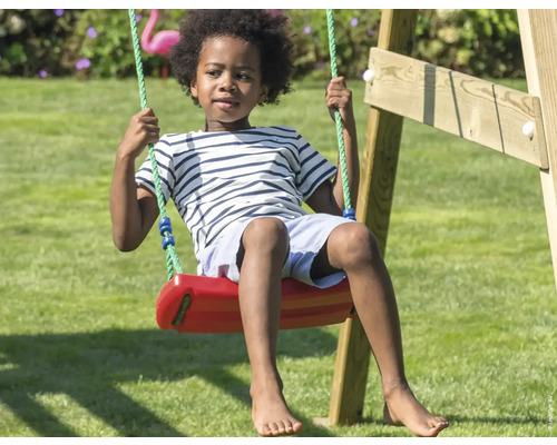 Kind schaukelt auf einer Schaukel im Garten.