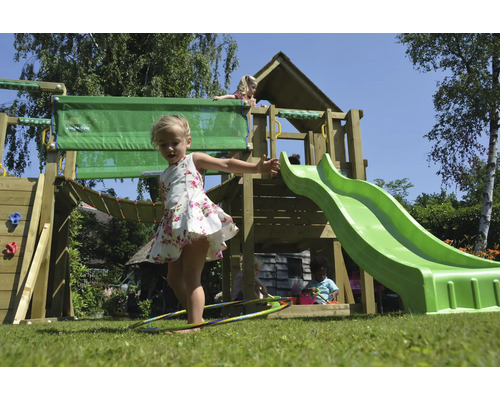 Spielplatz mit Rutsche, Schaukel und Kletterwand im Garten mit spielenden Kindern.
