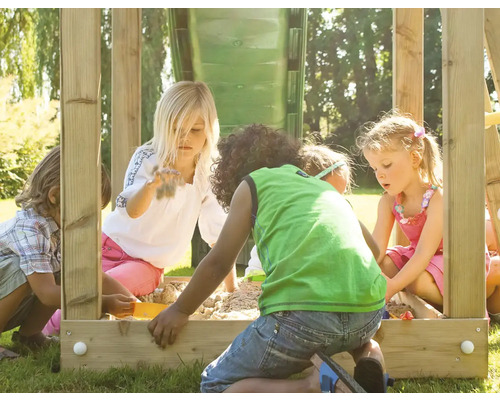 Kinder spielen im Sandkasten mit Rutsche auf dem Spielplatz.