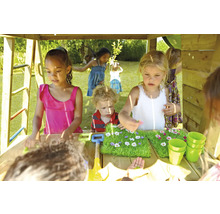 Kinder spielen in einem Spielhaus mit Sandkastentisch, Bechern und Gartengeräten.