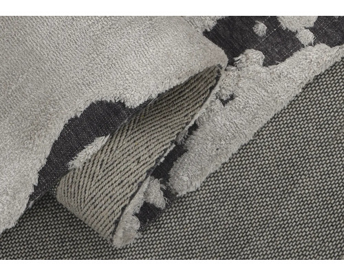 Detailansicht eines grau-schwarzen Teppichs mit Fransen