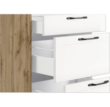 Schrank mit weißen Schubladen und schwarzen Griffen