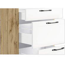 Detailansicht eines Schranks mit offenen, weißen Schubladen und Griffen