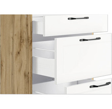 Schrank mit offenen weißen Schubladen und schwarzen Griffen