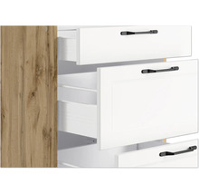 Detailansicht eines Schranks mit Schubladen in Holzoptik und weißen Schubladen mit schwarzen Griffen