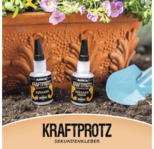 Zwei Flaschen Arka Kraftprotz Sekundenkleber Keramik vor einem Blumentopf und einer Schaufel
