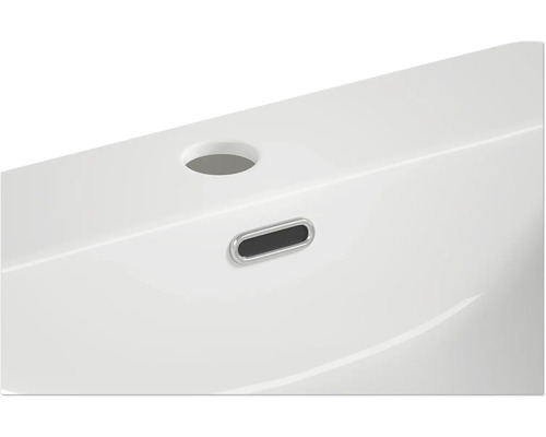 Detailansicht eines weißen Waschbeckens mit Überlauf und Hahnloch