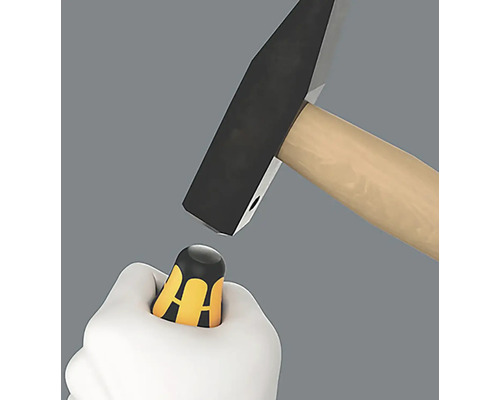 Ein Hammer schlägt auf einen Schraubendreher in einer Hand