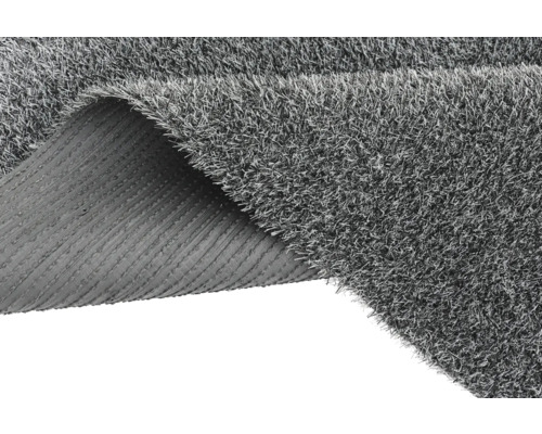 Grauer Kunstrasen mit gerollter Ecke, der die Rückseite zeigt