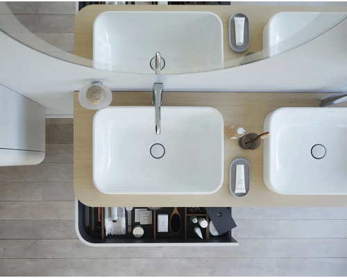 Badezimmeransicht von oben mit Doppelwaschbecken, Spiegel und geöffneter Schublade mit Badutensilien